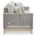 Gray woven lounge sofa set with light cushions and patterned throw pillows