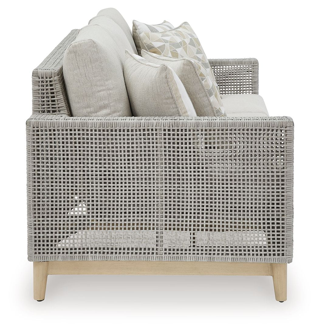Gray woven lounge sofa set with light cushions and patterned throw pillows
