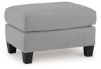 Gray upholstered ottoman with rounded top and dark tapered legs