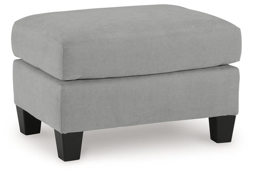 Gray upholstered ottoman with rounded top and dark tapered legs