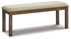 Beige upholstered bench with tufted top and nailhead trim on dark wood legs