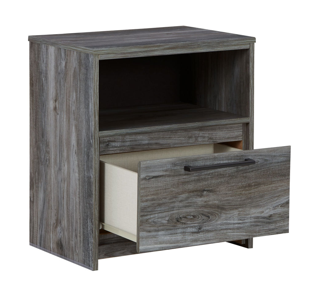 Gray one-drawer nightstand with open side shelf and drawer pulled out, wood grain.