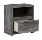 Gray one-drawer nightstand with open side shelf and drawer pulled out, wood grain.