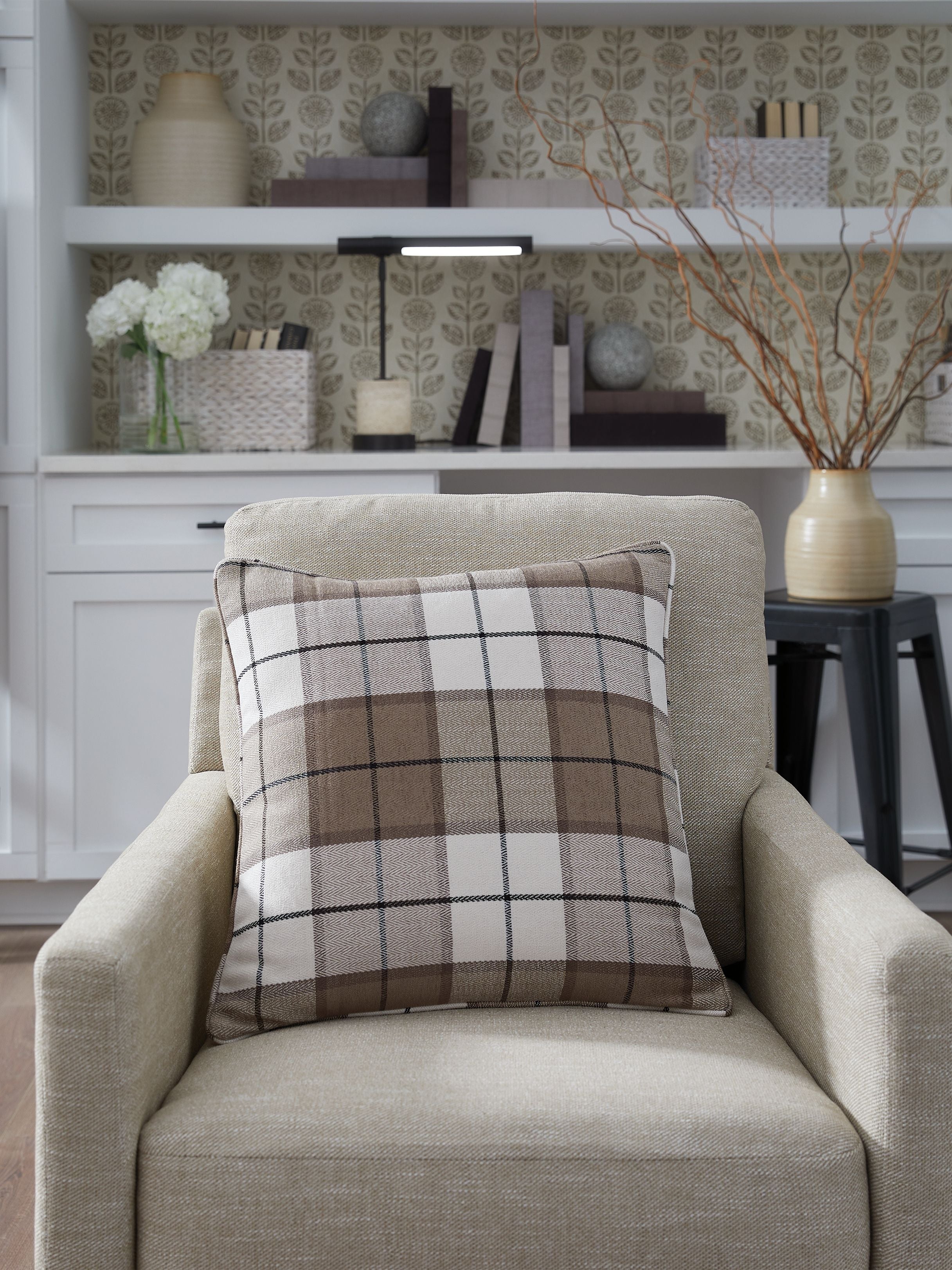 Plaid cushion with dark brown and gray checks on a light base; square pillow