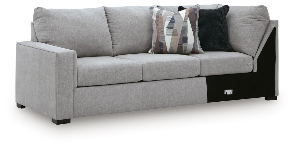 Grey upholstered sofa with corner wedge, black base panels, two front armrests and cushions