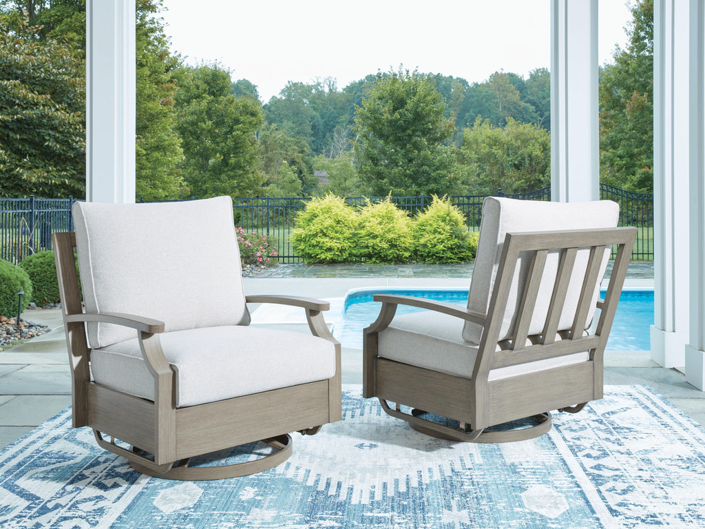 Swivel glider chair with light beige cushion and dark brown frame on outdoor patio