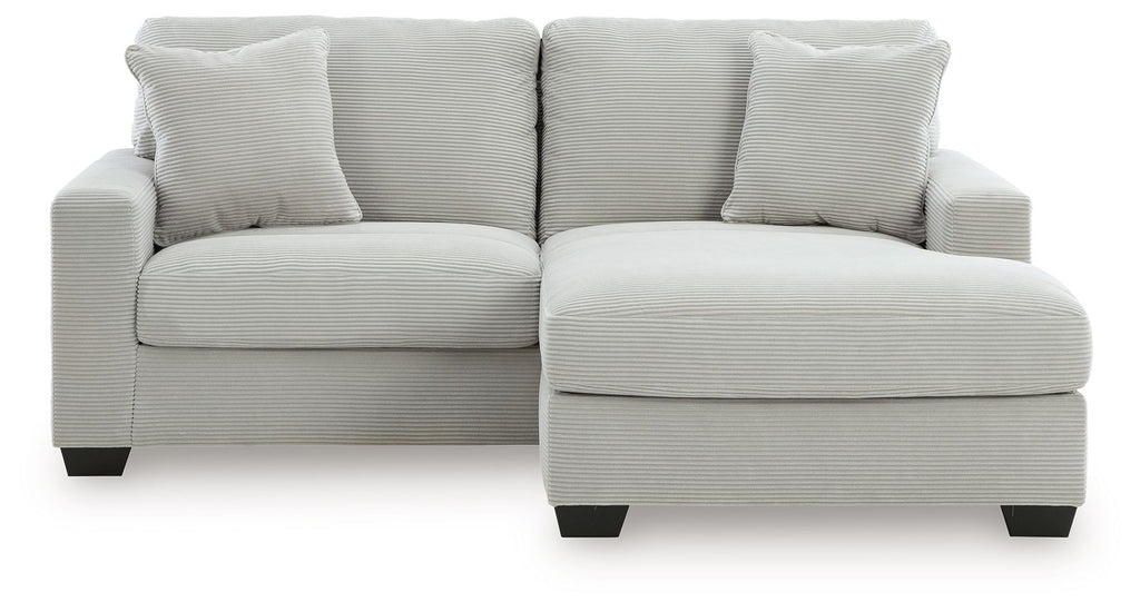 White sofa chaise with three front seat cushions and a chaise ottoman extension