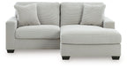 White sofa chaise with three front seat cushions and a chaise ottoman extension