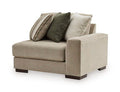 Corner chair in light beige fabric with two throw pillows (green and neutral striped)