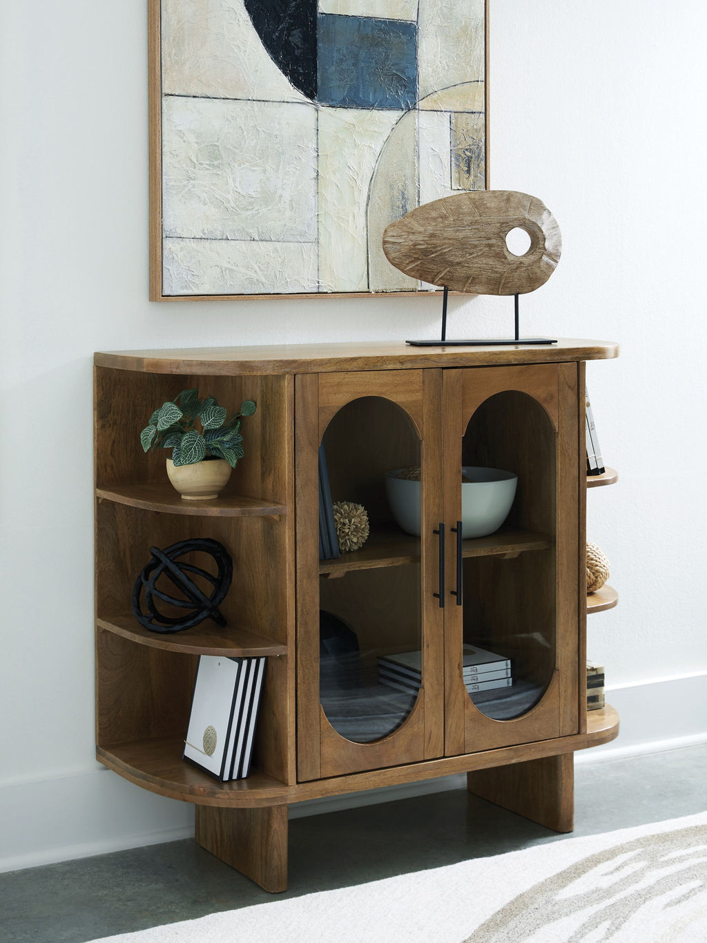 Light brown wood cabinet with oval door panels and interior shelves