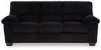 Black upholstered sofa with padded armrests, tufted back cushions, and square legs.