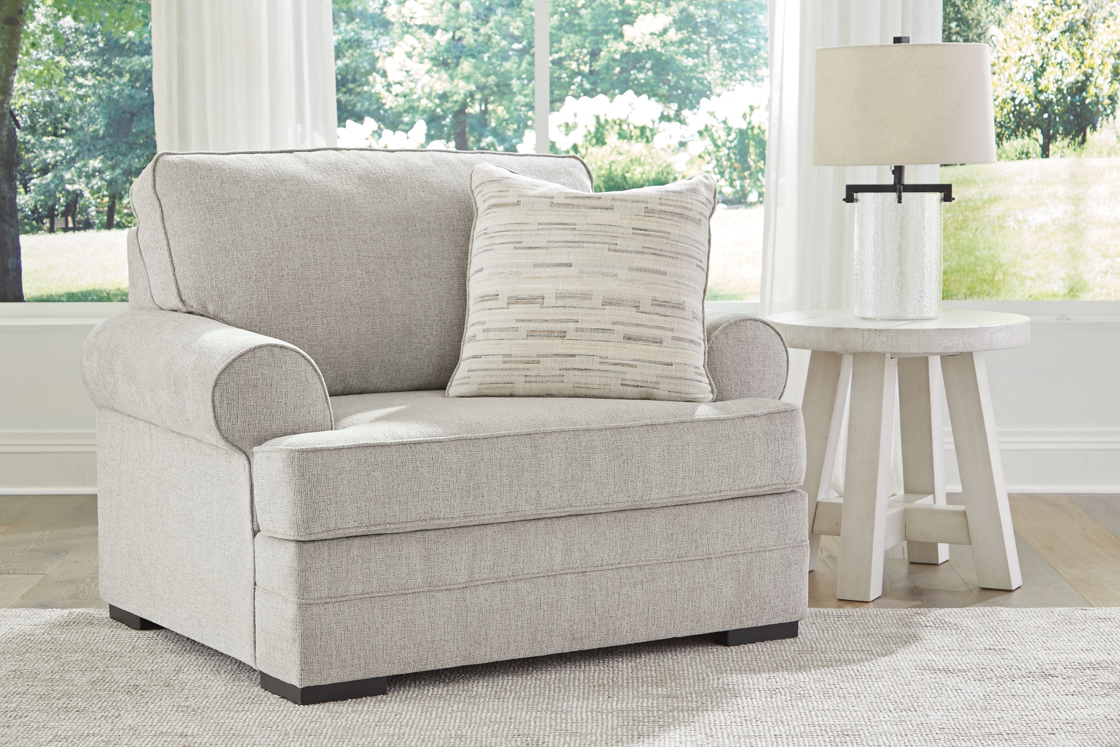 Light gray chair and a half with back cushion and striped throw pillow
