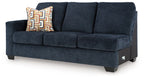 Ink blue fabric sofa side profile with square arms, three seat cushions, and throw pillow