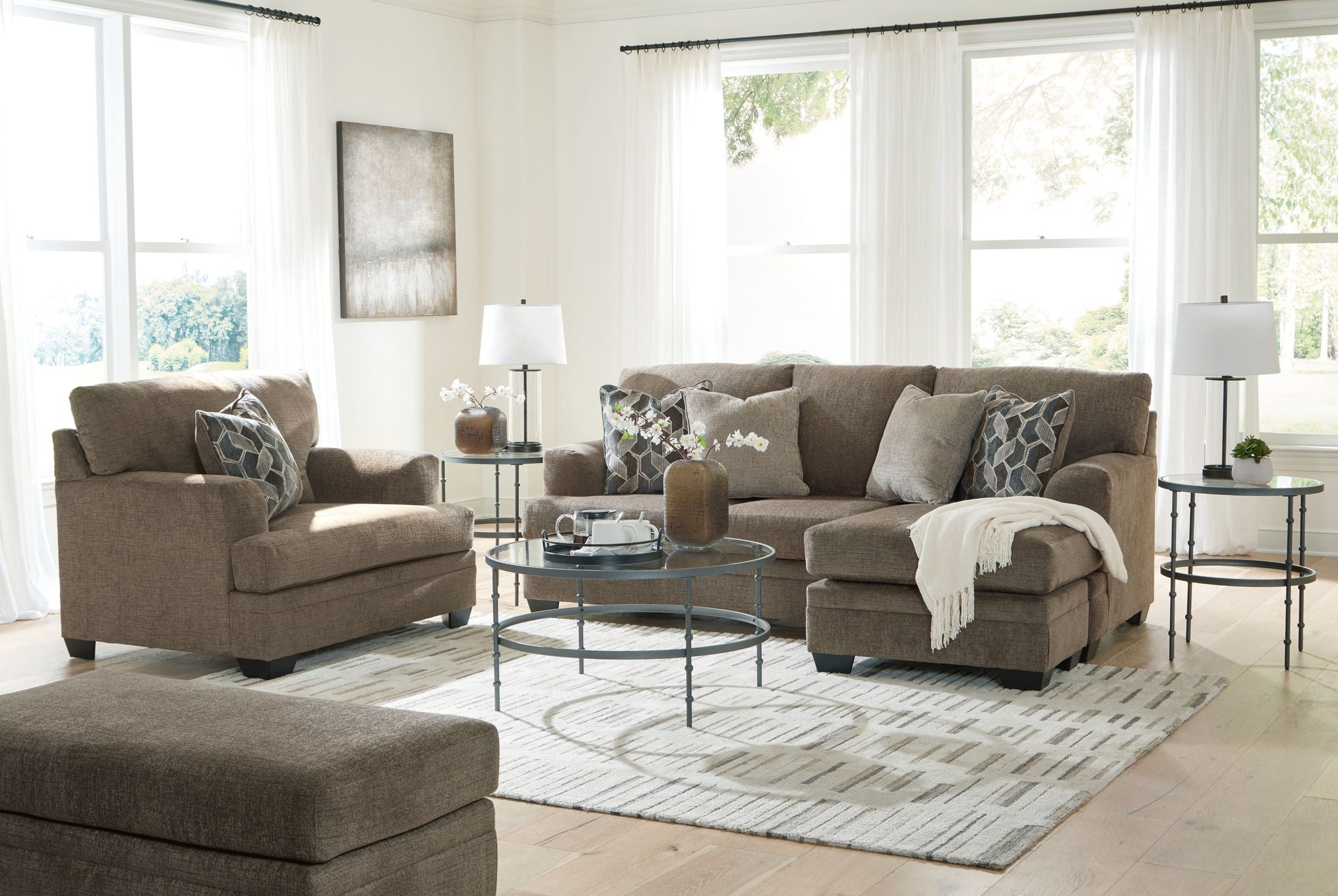 Taupe fabric living room sectional set with chaise, sofa, ottoman, and patterned pillows