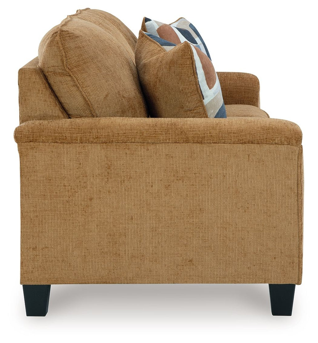 Beige sofa with two back cushions and a patterned accent pillow