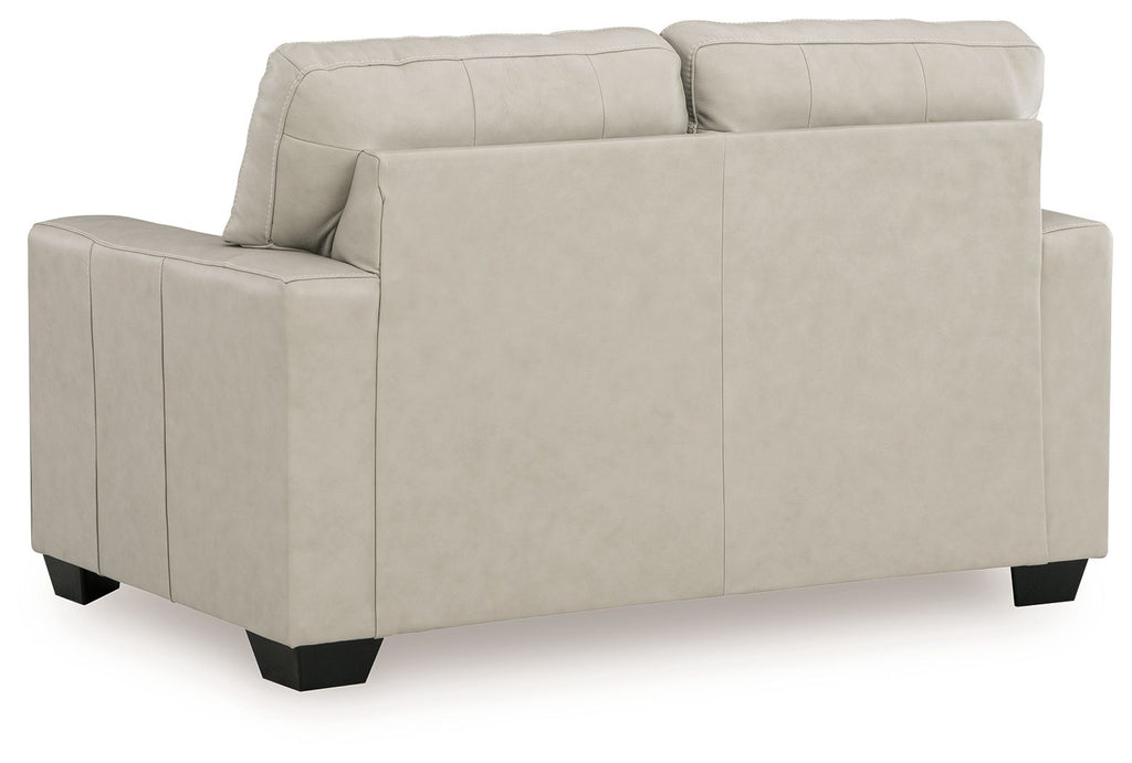 Light beige leather-look loveseat with tufted back and smooth seat, visible arm panel