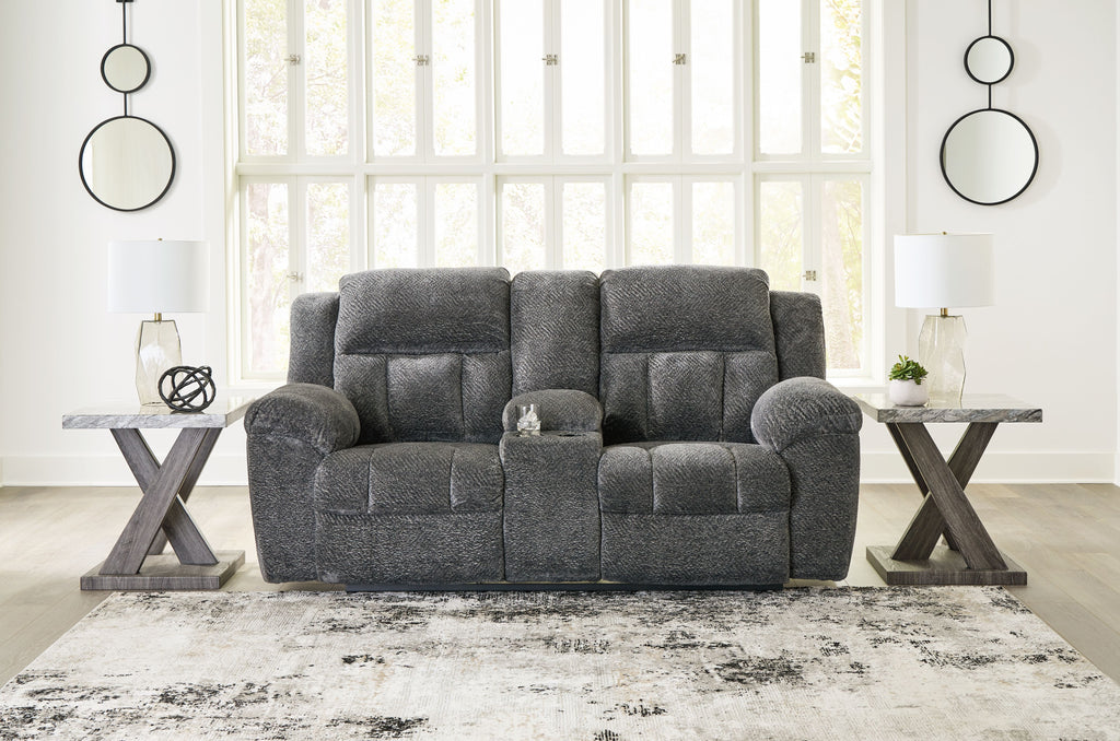 Dark gray double reclining loveseat with tufted back cushions and padded armrests
