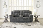 Dark gray double reclining loveseat with tufted back cushions and padded armrests