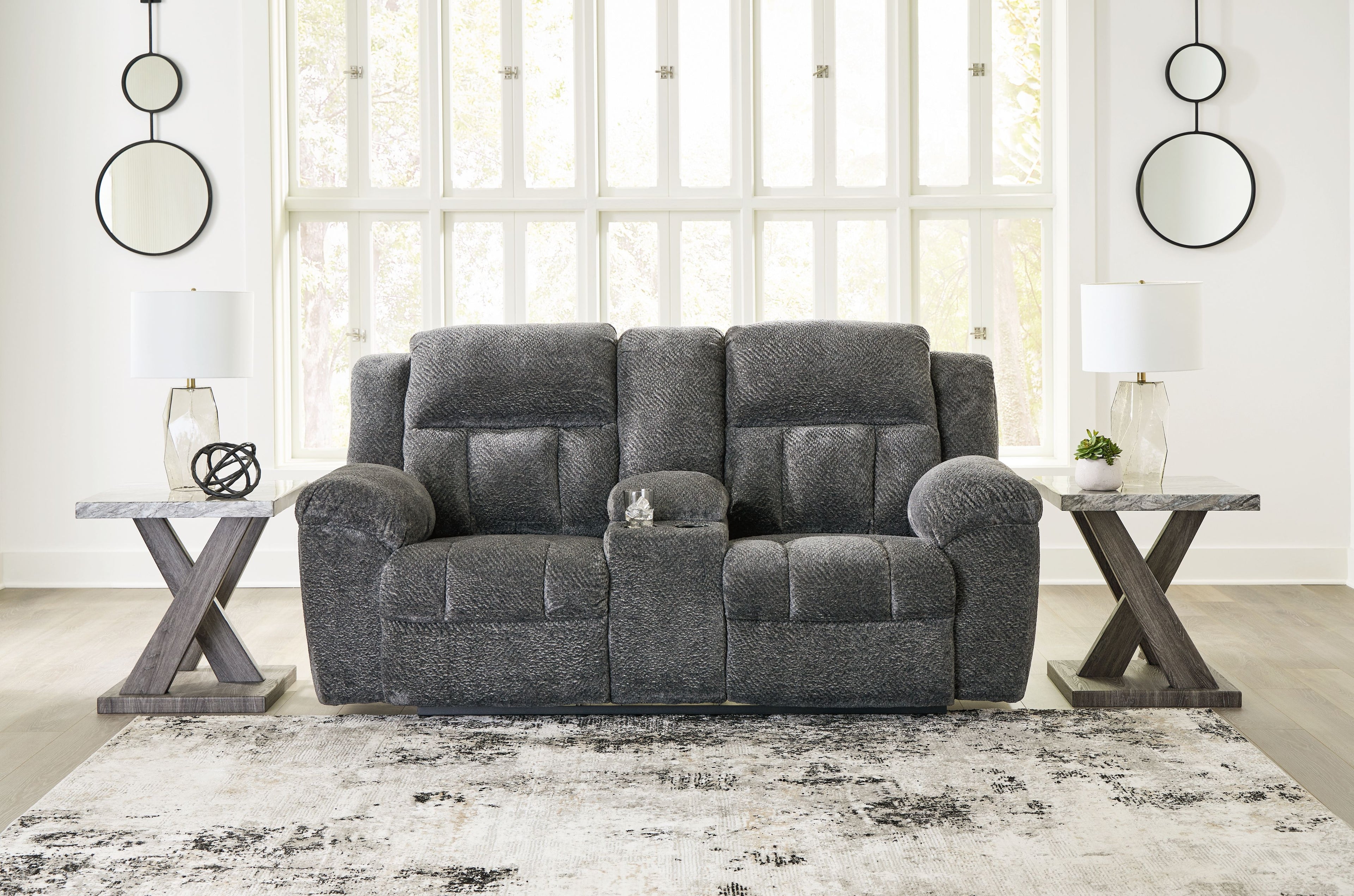 Dark gray double reclining loveseat with tufted back cushions and padded armrests