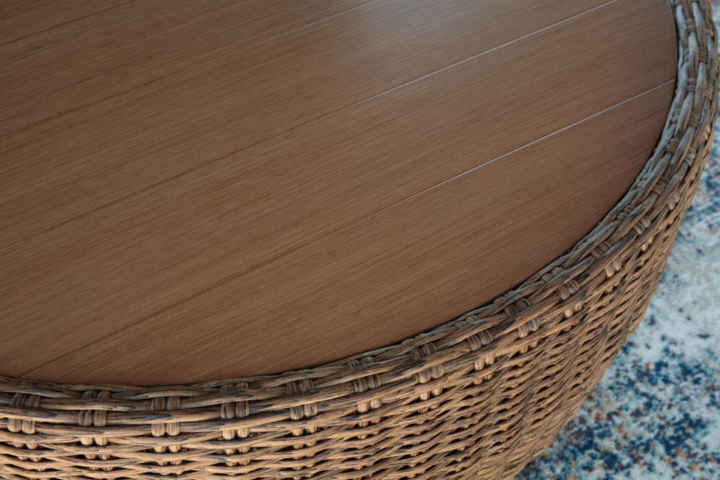 Woven wicker side and round wooden tabletop on beige-brown cocktail table