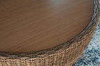 Woven wicker side and round wooden tabletop on beige-brown cocktail table