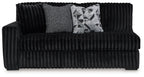 Tufted ribbed onyx black sofa with armrests, two accent pillows, and wide seat