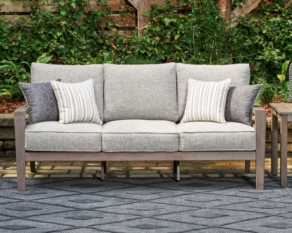 Gray outdoor sofa with two side throw pillows, striped and patterned cushion inserts