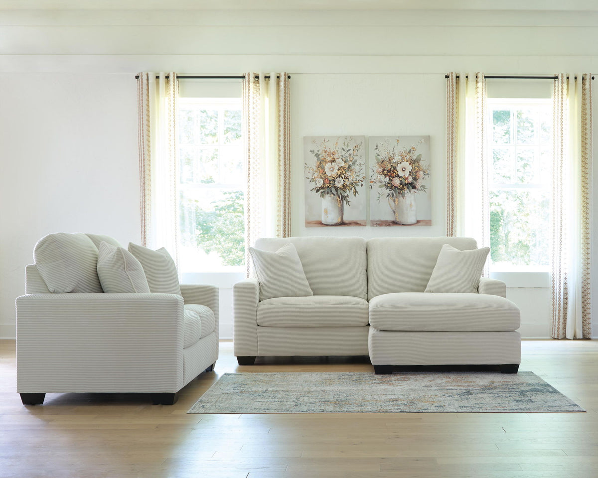 Light gray sofa and loveseat set with five throw pillows and dark block feet