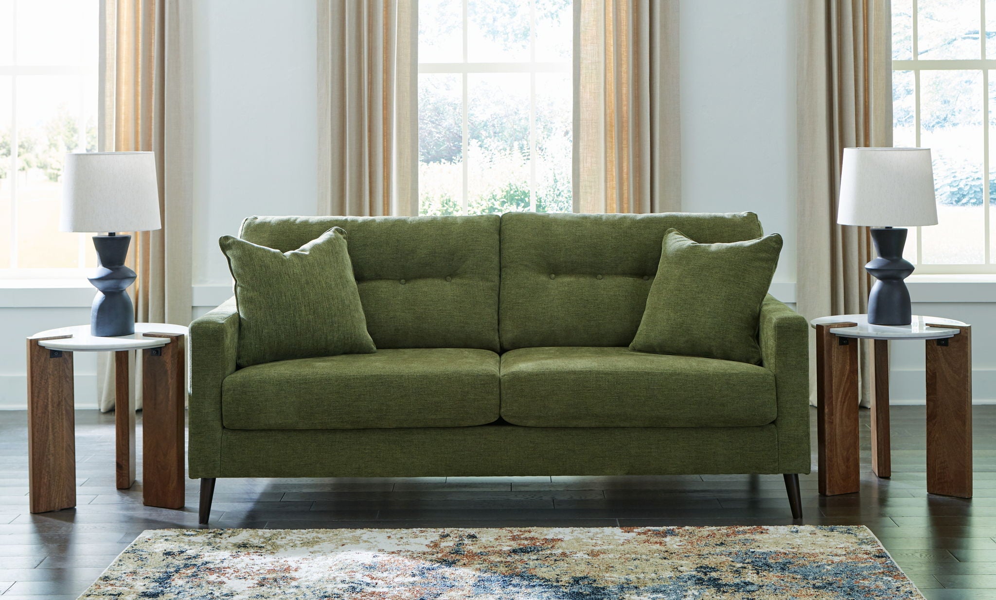 Green upholstered loveseat sofa with two front seat cushions and two throw pillows