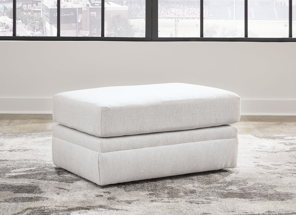 Light beige ottoman with two-tier cushioned base and rounded top, short legs