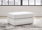 Light beige ottoman with two-tier cushioned base and rounded top, short legs