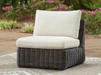 Armless wicker chair with beige cushions on dark brown woven body