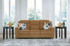 Honey reclining sofa with two patterned throw pillows, wide front view