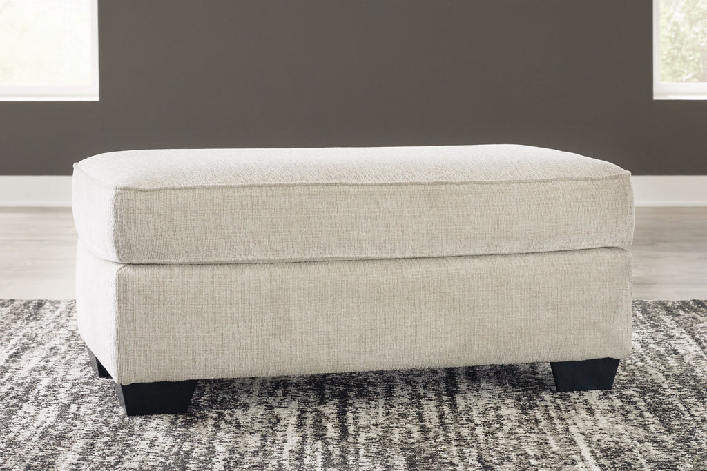 Light beige ottoman with rectangular cushion and dark tapered legs