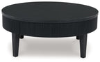 Black round cocktail table with ribbed skirt and four tapered legs