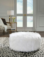 Oversized ottoman with shaggy white faux fur upholstery and rounded shape