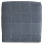 Square upholstered ottoman in dark gray with stitched grid paneling on top