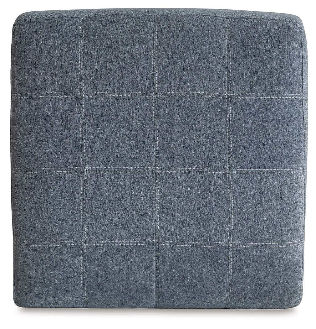 Square upholstered ottoman in dark gray with stitched grid paneling on top
