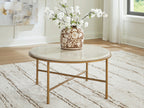 Round table with light stone-look surface, gold frame, and two-tier cross support bar.
