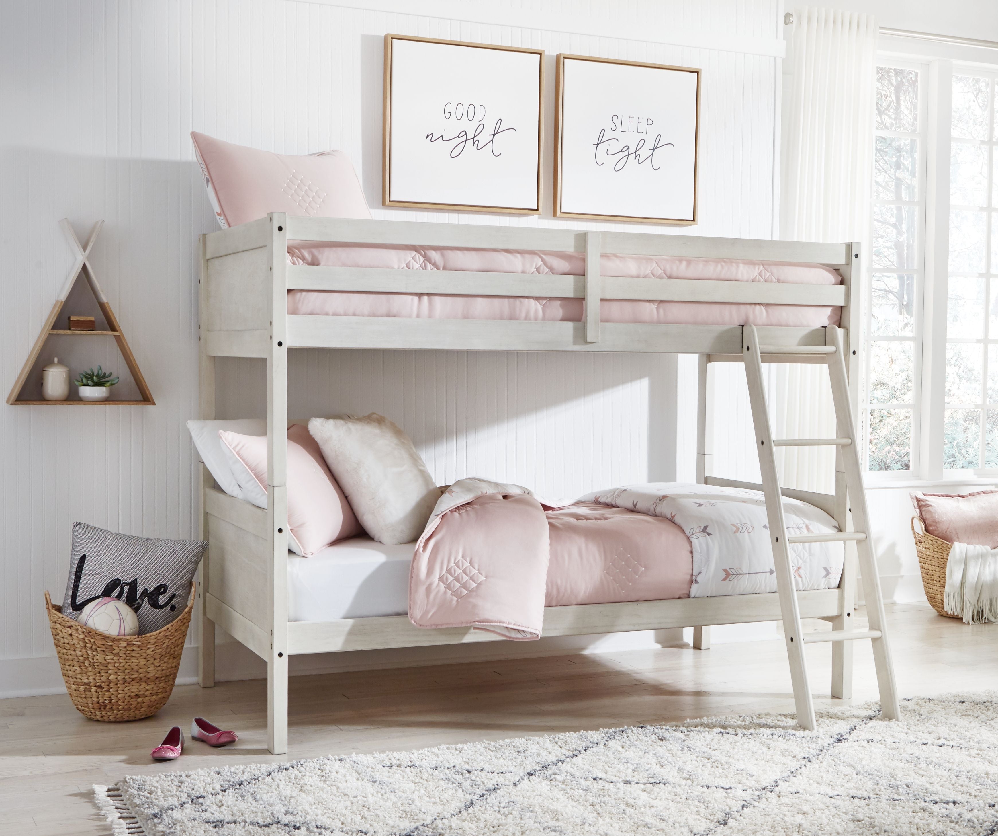 Antique white twin over twin bunk bed with ladder and pink-and-white bedding