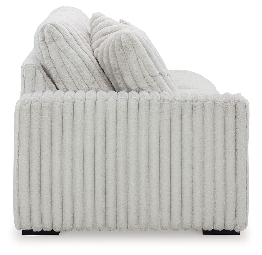 Light gray ribbed sofa back with layered cushions and thick seat bolster