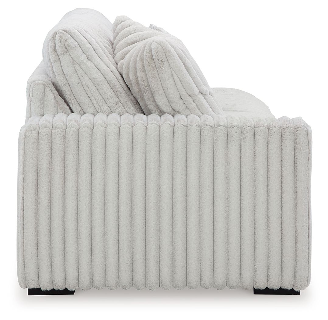 Light gray ribbed sofa back with layered cushions and thick seat bolster