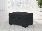 Square upholstered ottoman in dark fabric with cushioned lid and block legs