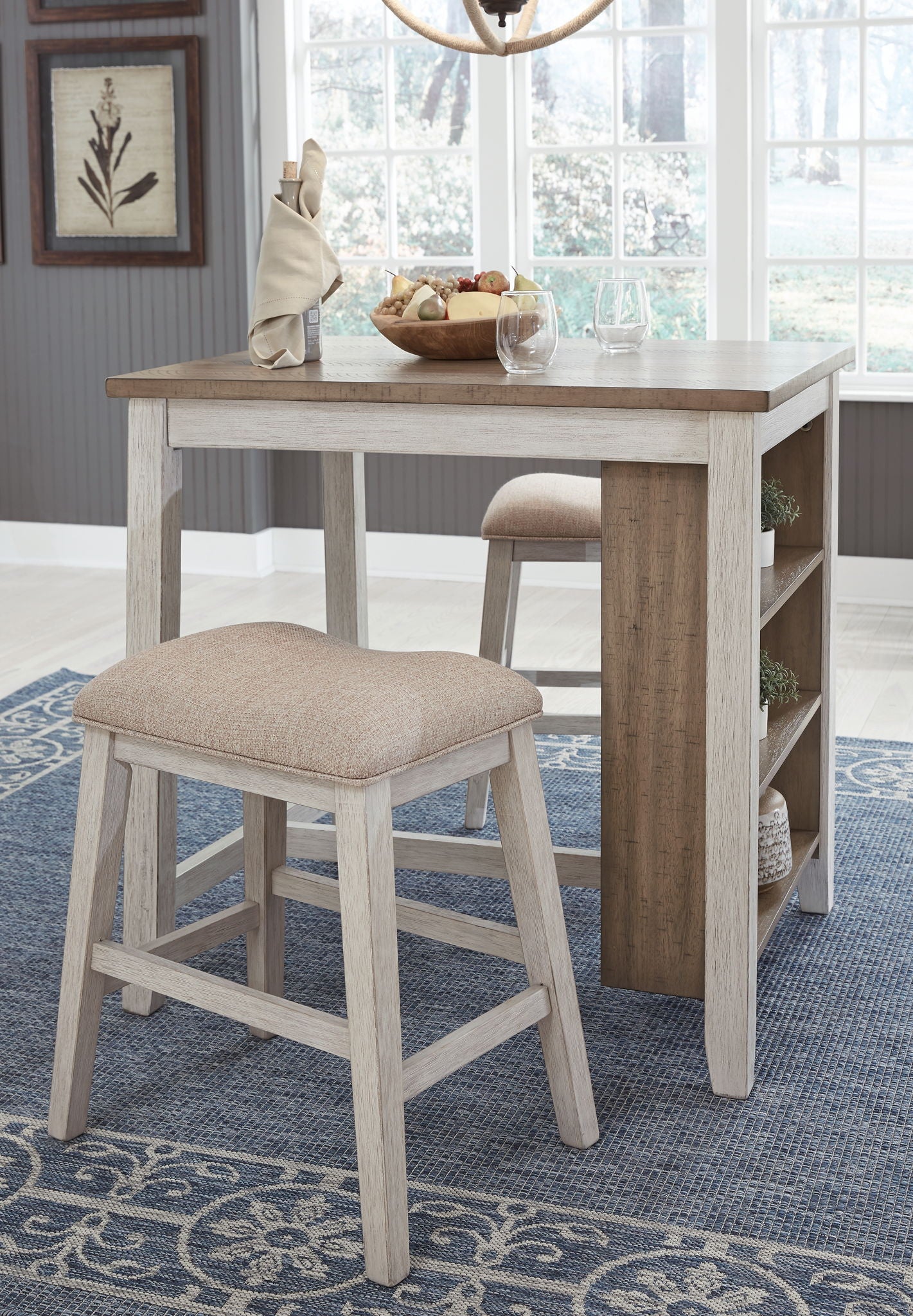 Rectangular counter table with open shelf and beige upholstered stool, side view