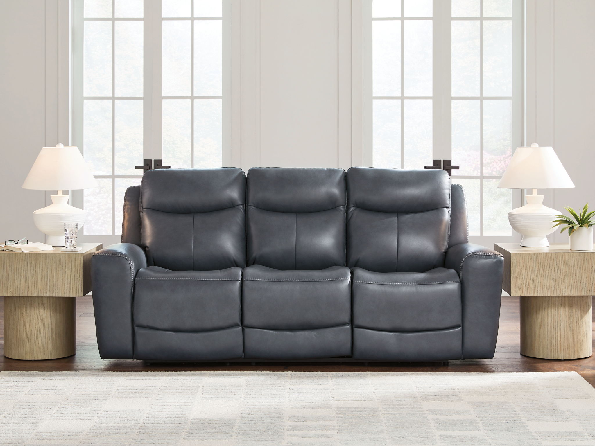 Blue power reclining sofa with three padded seats and adjustable headrests