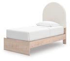 Upholstered panel bed with beige headboard, white mattress, and light wood base