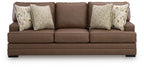 Caramel brown sofa with tufted back cushions and patterned side pillows, wide seat
