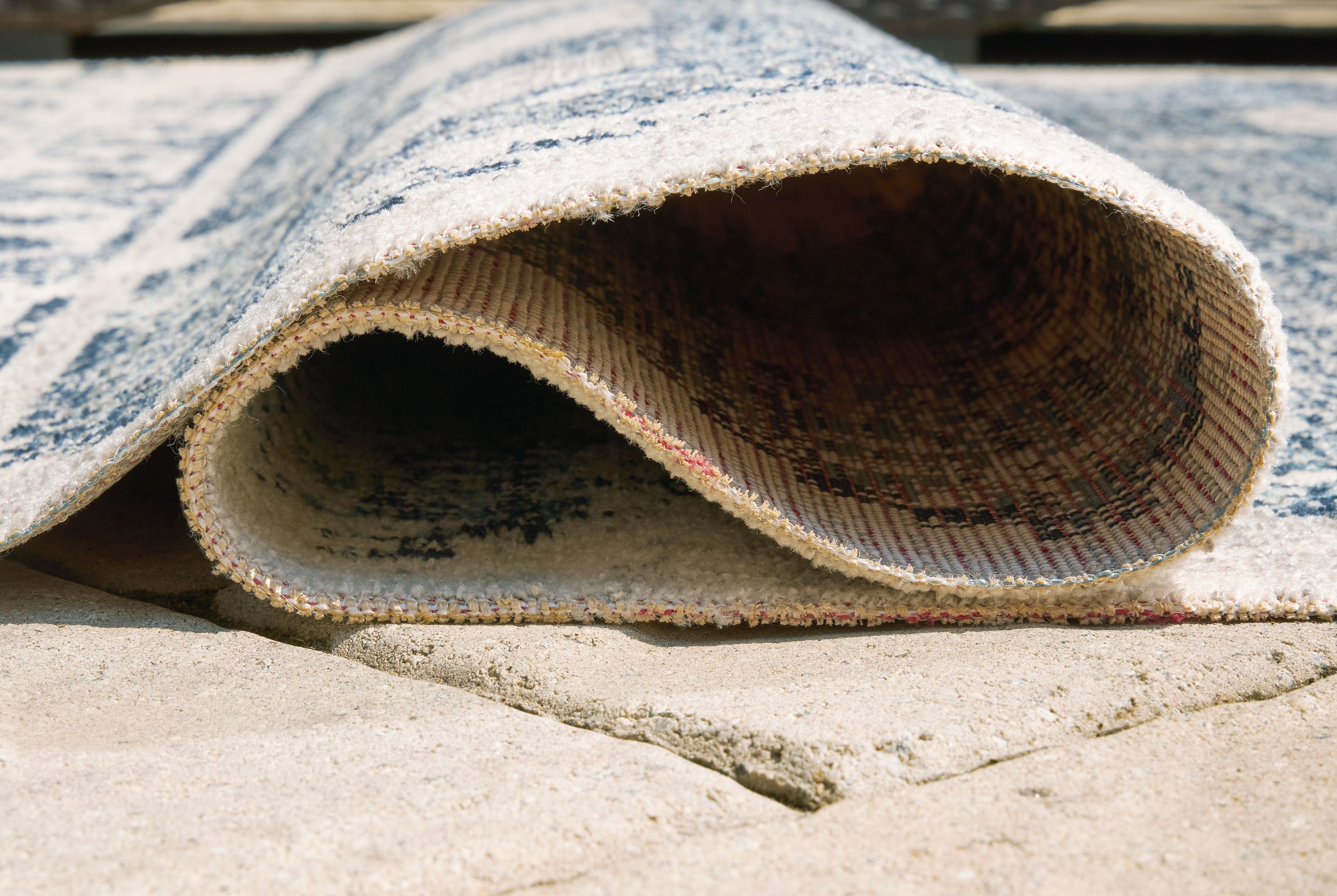 Blue and ivory area rug rolled edge showing short cut pile