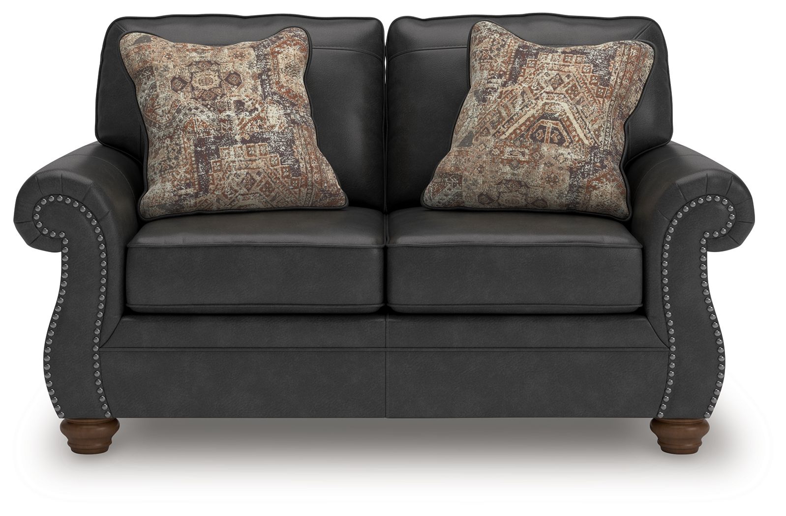Dark gray loveseat with two patterned throw pillows and studded arm trim