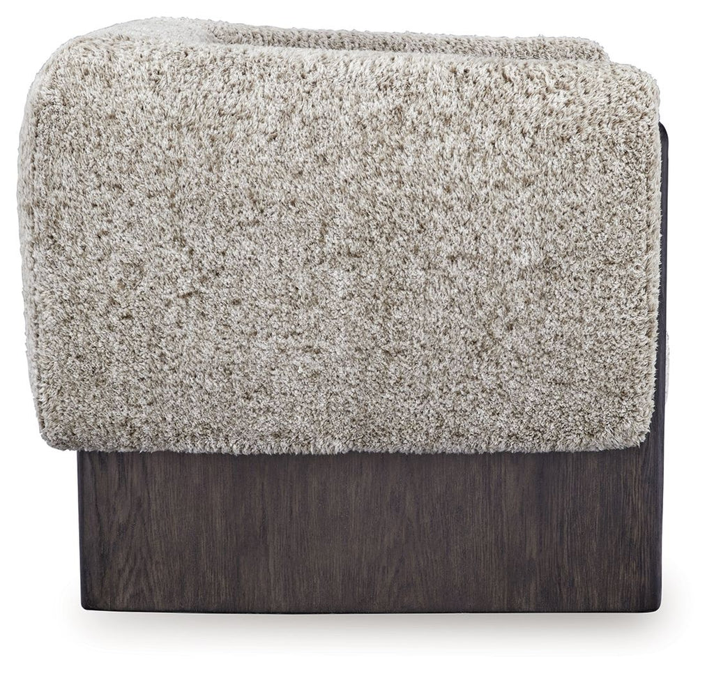 Accent chair with textured oatmeal boucle back panel and dark wood base.